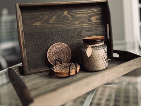 Wooden tray featuring rustic coasters and a decorative candle jar for home decor.
